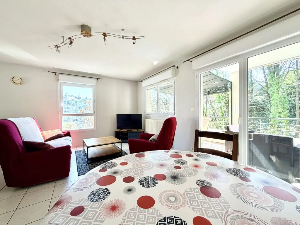 table avec chaises, canapé et fauteuil, télévision