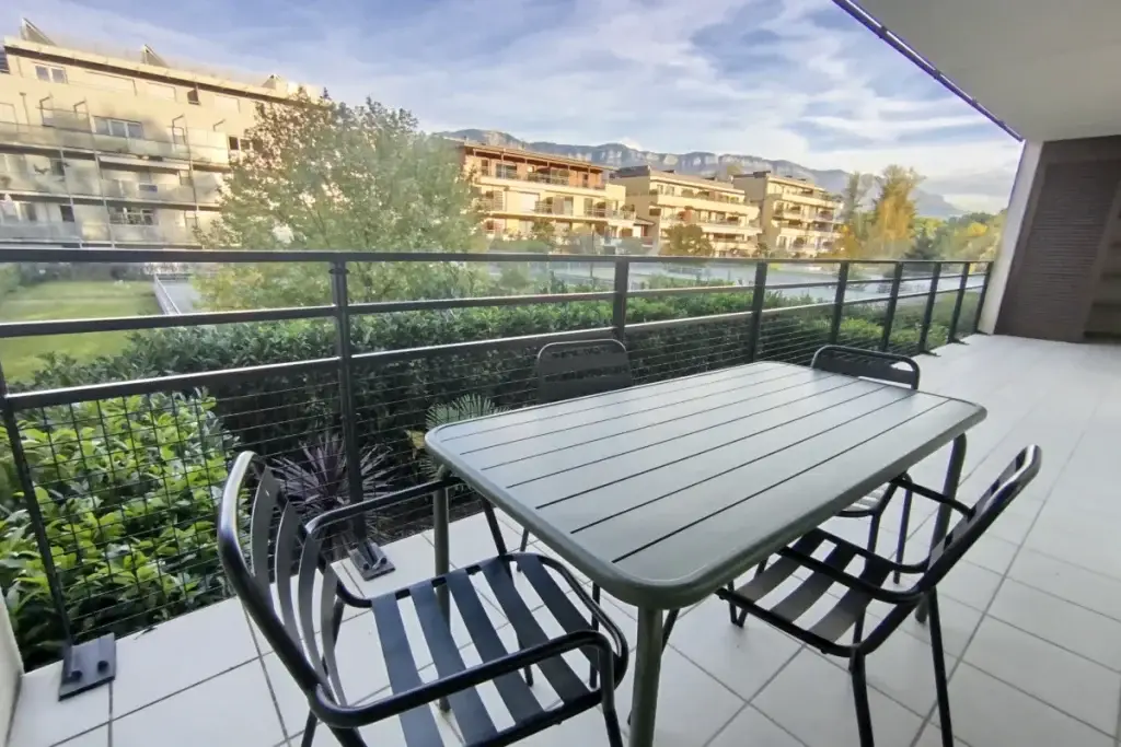terrasse avec table et 4 chaises vue sur les montagnes
